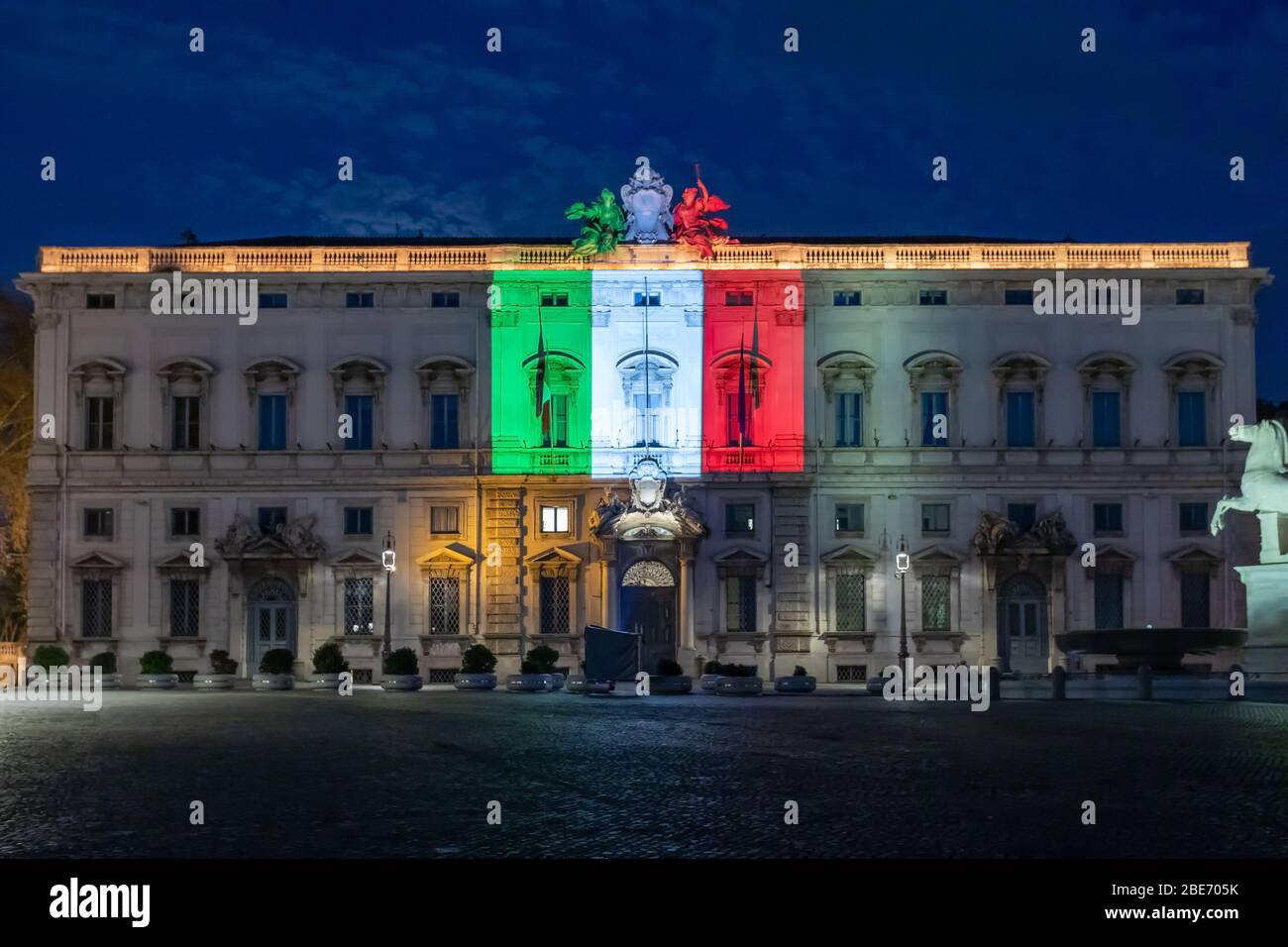 Roma, Italia - 7 aprile 2020: Piazza del Quirinale in serata in ora blu, illuminata con i colori della bandiera italiana sulla facciata del Th Foto Stock