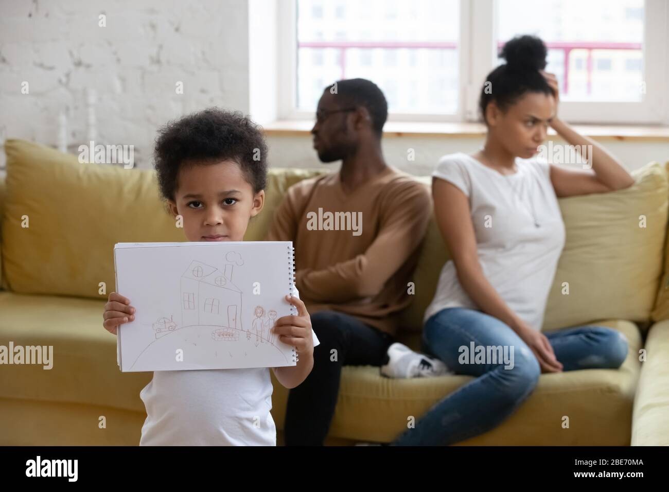 Primo piano ragazzo afro-americano che soffre di conflitto tra i genitori. Foto Stock