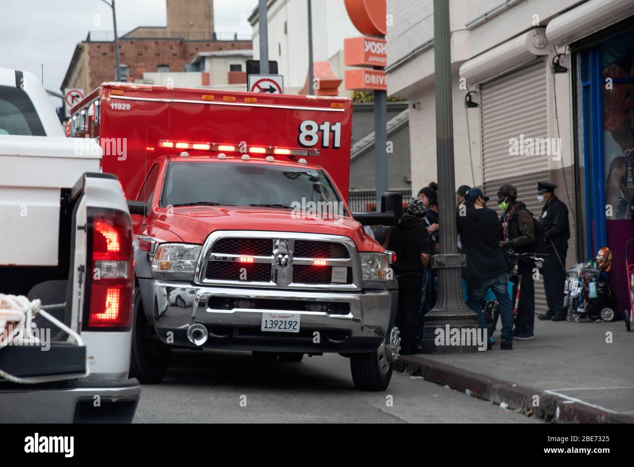Los Angeles, CA/USA - 9 aprile 2020: I paramedici assistono una persona senza tetto per le strade durante l'epidemia di coronavirus Foto Stock