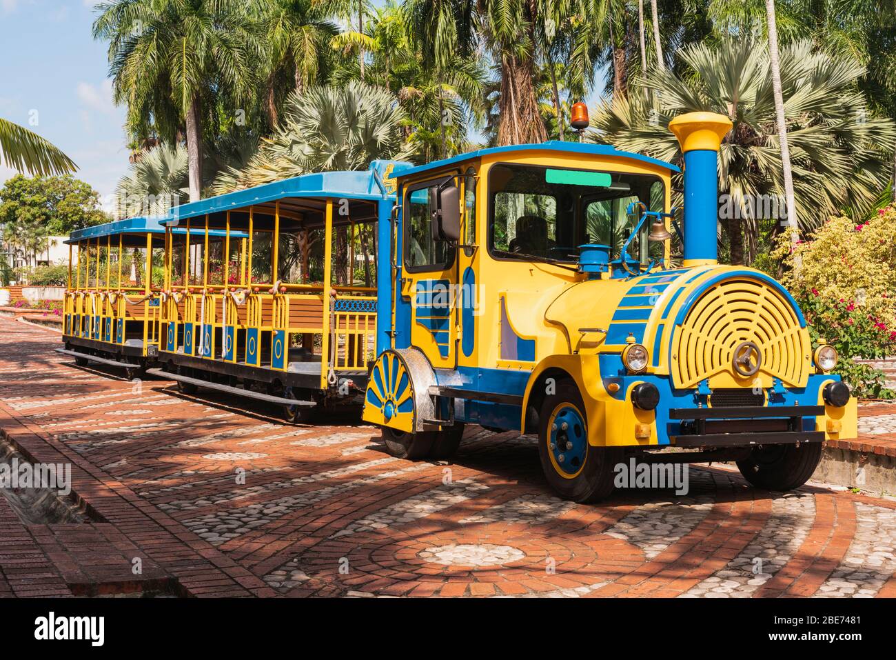 treno turistico, blu e giallo in un parco pronto a partire senza persone in un bellissimo parco Foto Stock