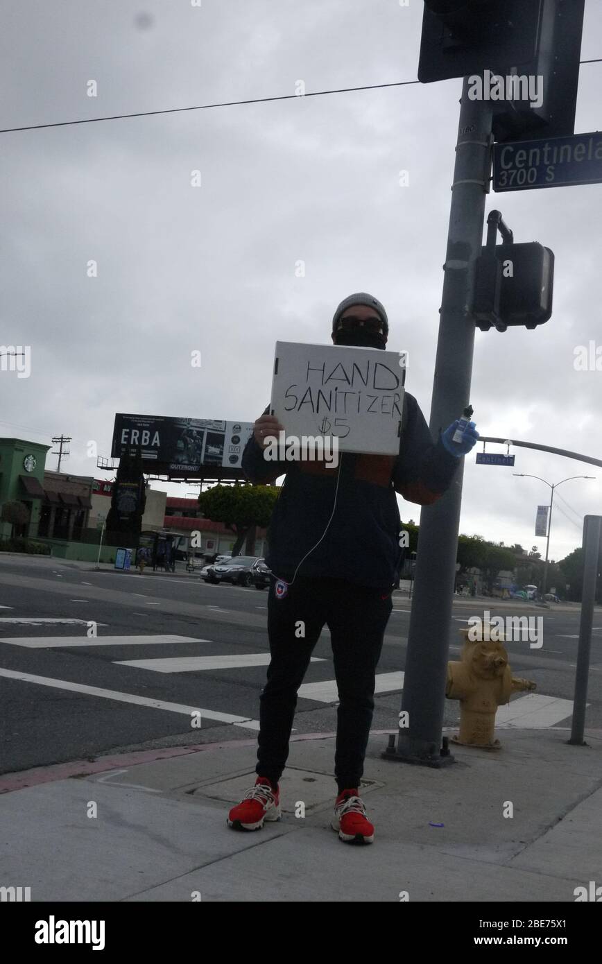 I venditori ambulanti vendono prodotti per la sanificazione delle mani e maschere lungo il lato di Venice Blvd. Foto Stock