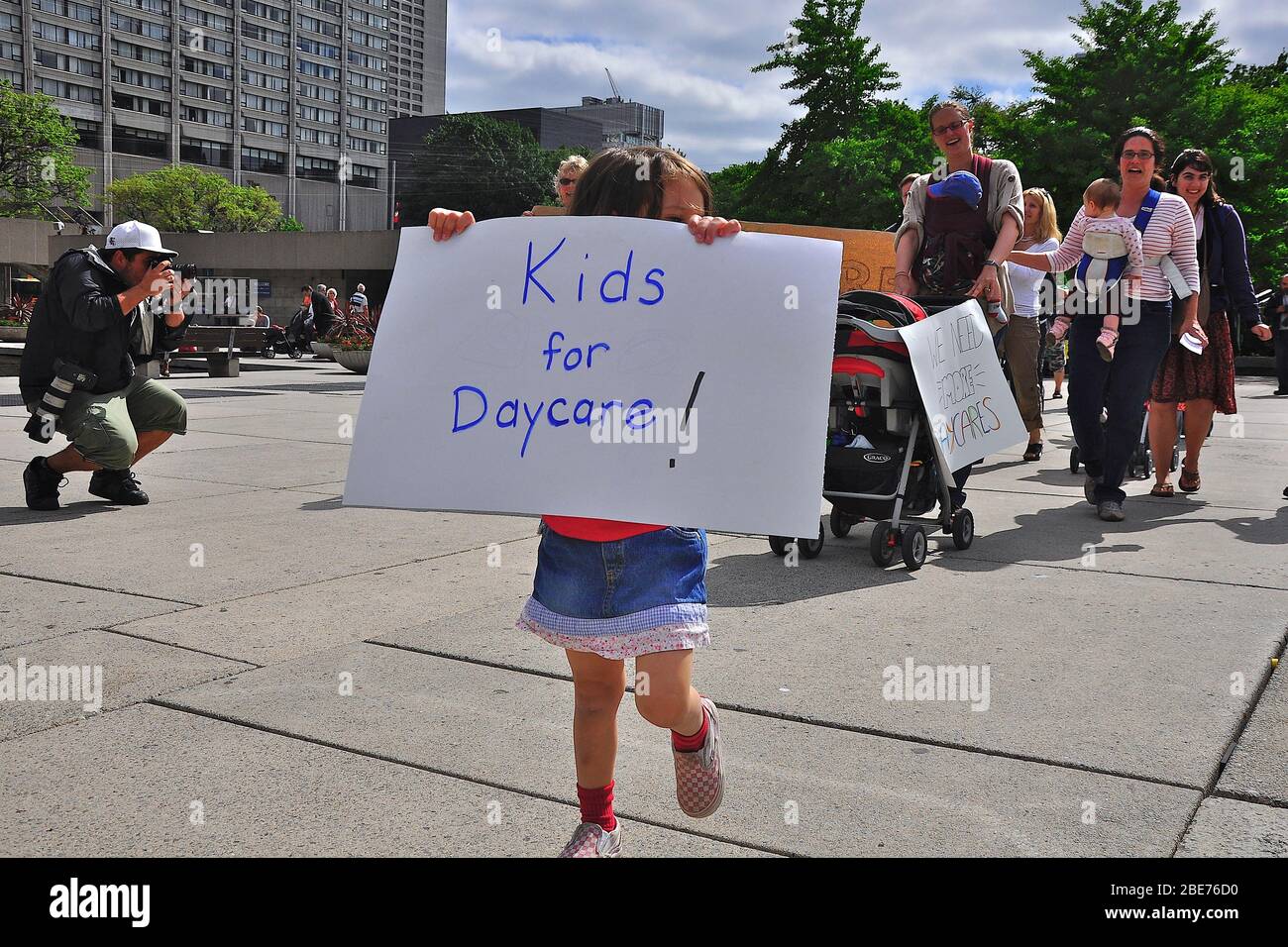 Toronto, Ontario, Canada - 06/09/2009: Il bambino dimostra sulla questione della cura del giorno con un cartello a Toronto, Foto Stock