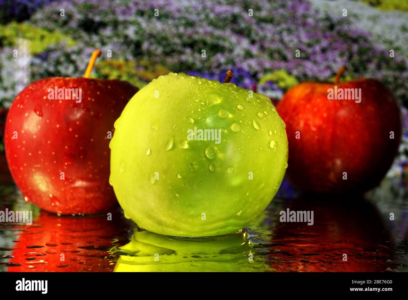 Fotografia alimentare: Immagine a colori delle mele riprese da primo piano in macro con gocce d'acqua e riflessi. Immagine di frutta fresca per il download o l'arte Foto Stock