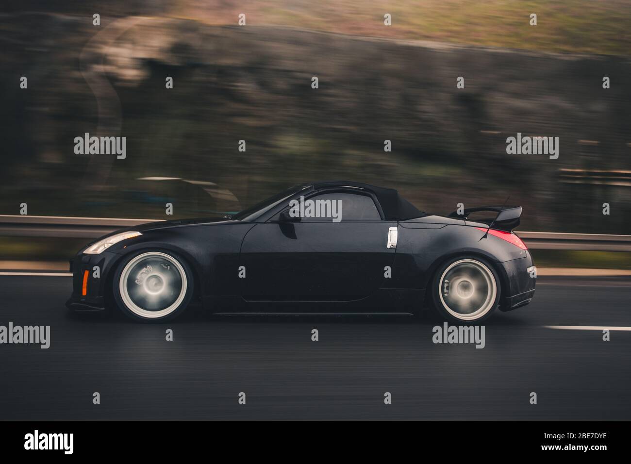 Cabriolet nero che guida su colline Foto Stock