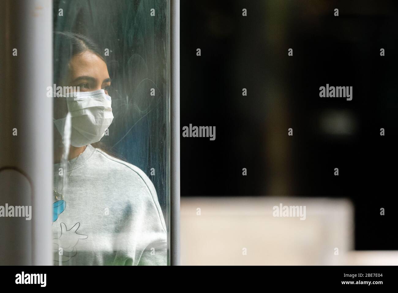 Melbourne, Australia, 12 aprile 2020. Una donna che indossa una maschera attende un tram durante la crisi COVID-19 a Melbourne, Australia. Credit: Dave Hewison/Alamy Live News Foto Stock