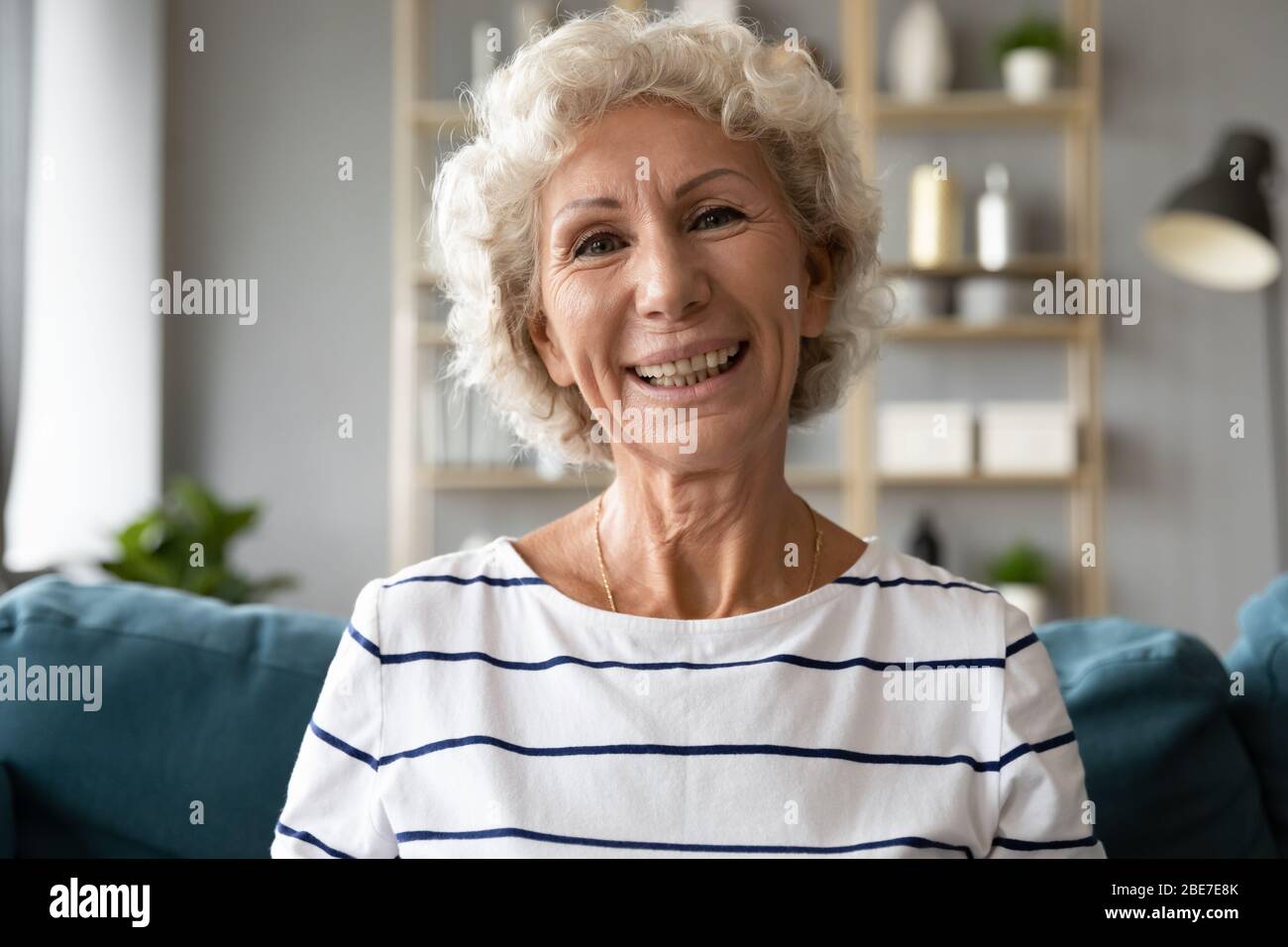 Ritratto di colpo di testa sorridente donna anziana che chiacchiera in linea Foto Stock