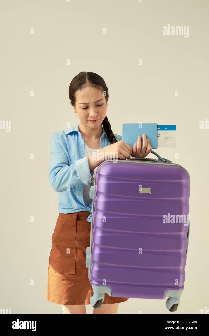 Donna con valigia pesante con abiti per le vacanze. Questo è un mondo femminile. Foto Stock