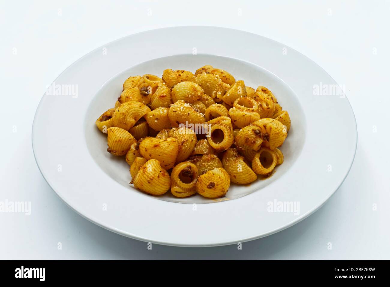 Pasta rigata, pasta con tubetto in salsa bolognese in piatto bianco. Foto Stock