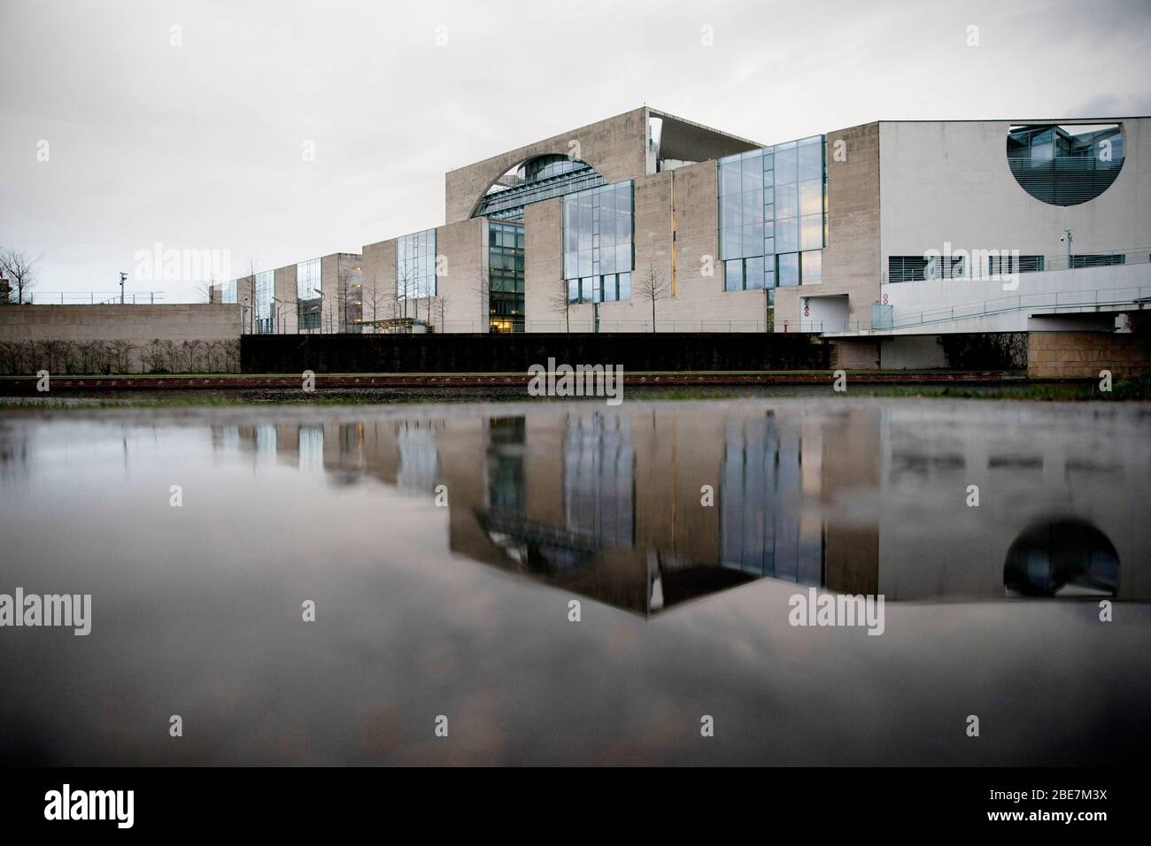 13 aprile 2020, Berlino: La Cancelleria federale si riflette in un pouddle. Per rallentare la diffusione del coronavirus, il governo federale ha fortemente limitato la vita pubblica. Foto: Christoph Soeder/dpa Foto Stock