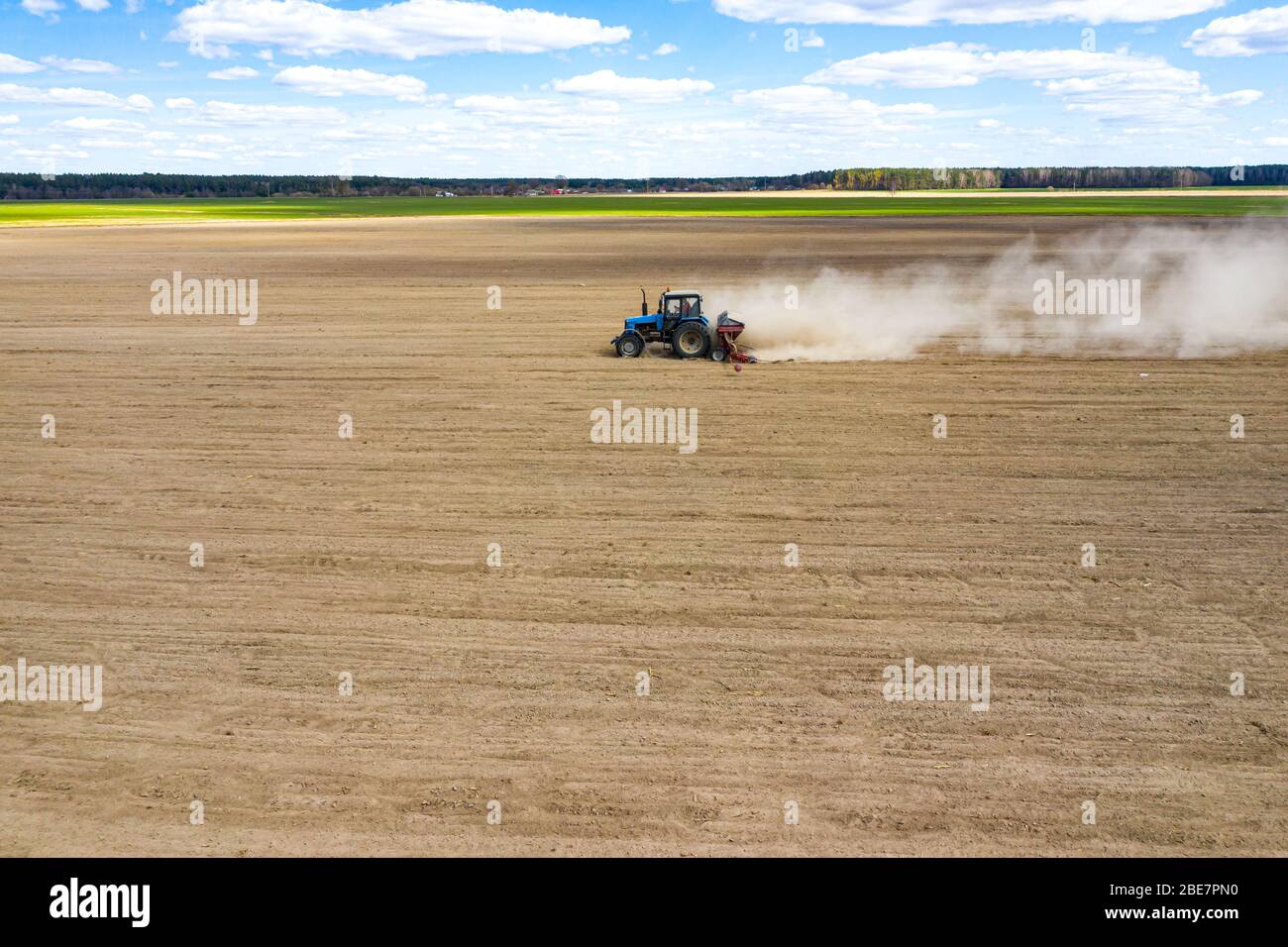 vista laterale del trattore che semina semi di mais nel campo, foto con drone ad angolo elevato Foto Stock