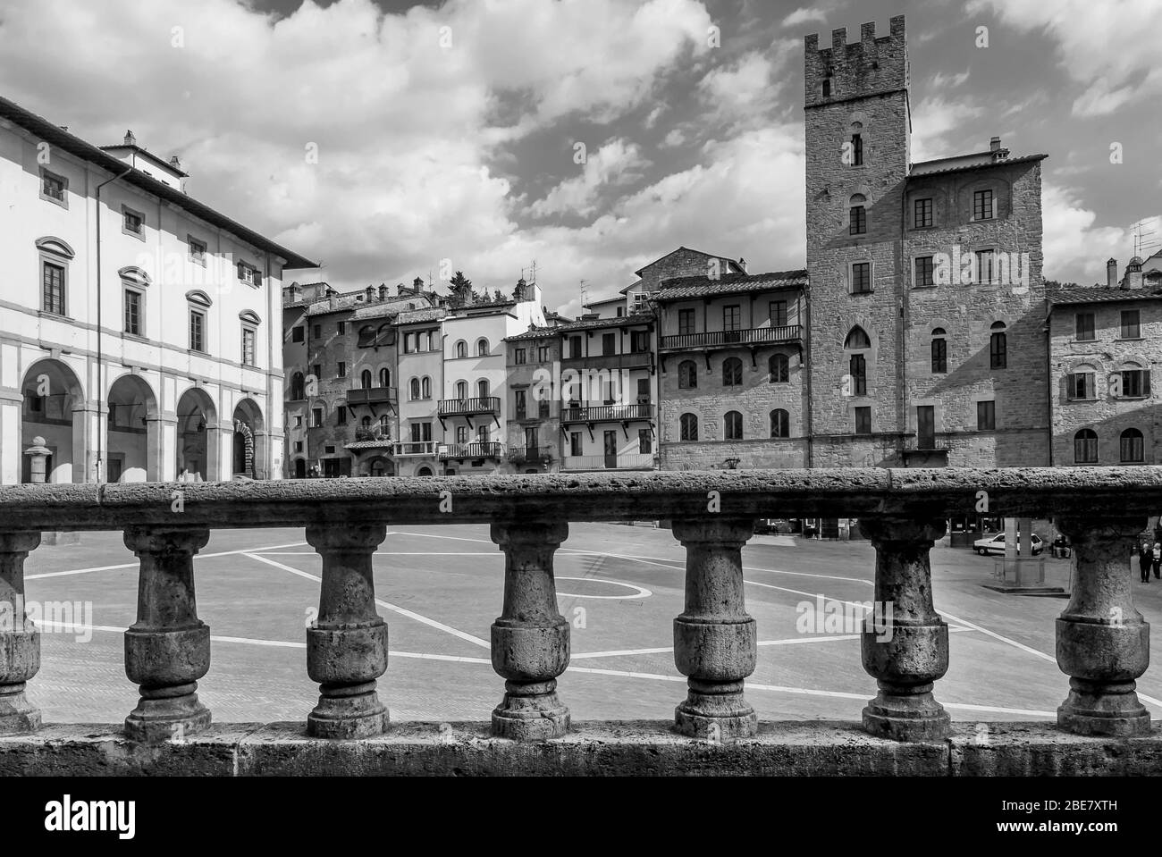 Vista in bianco e nero della famosa Piazza Grande nel centro storico di Arezzo, Toscana, Italia, contro un bel cielo Foto Stock