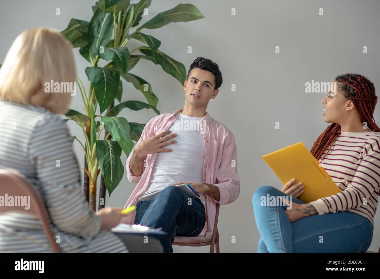 Dubbi. Giovane uomo in camicia rosa che guarda dubbioso Foto Stock