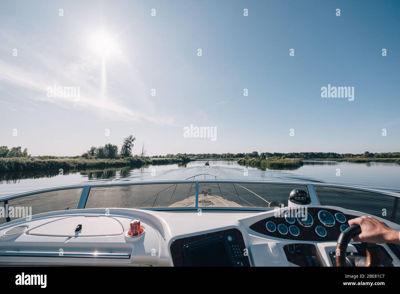 Uomo come capitano barca a vela durante la giornata estiva su un fiume Foto Stock