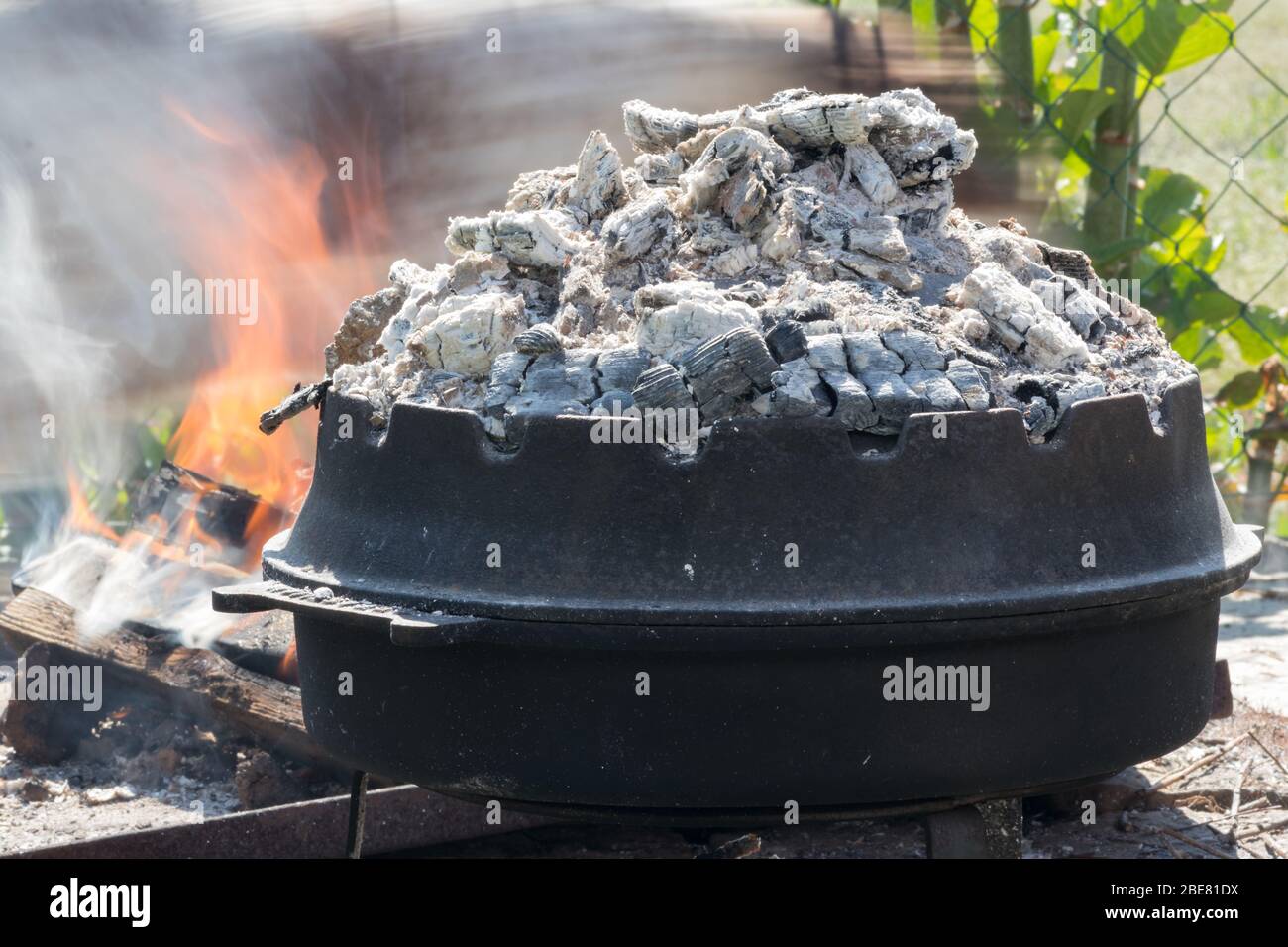 Cucina di tradizionale pasto croato Peka in pentole di metallo chiamato  sac, sach o sache. Camino con fuoco aperto e bruciare le costine.  L'ingrediente preparato Foto stock - Alamy