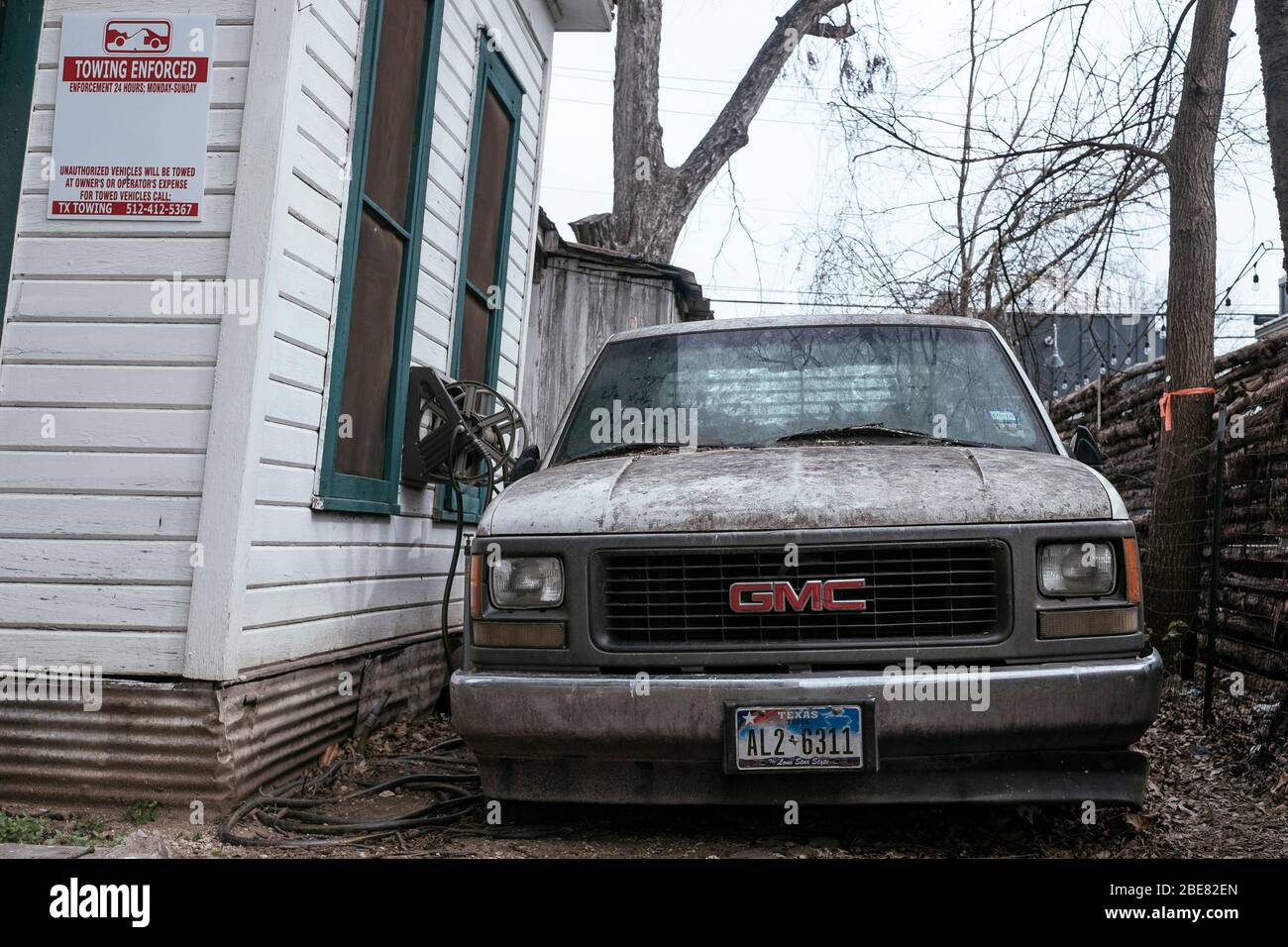 Una casa dilapidiata ad Austin, Texas, con un camion GMC parcheggiato all'esterno Foto Stock