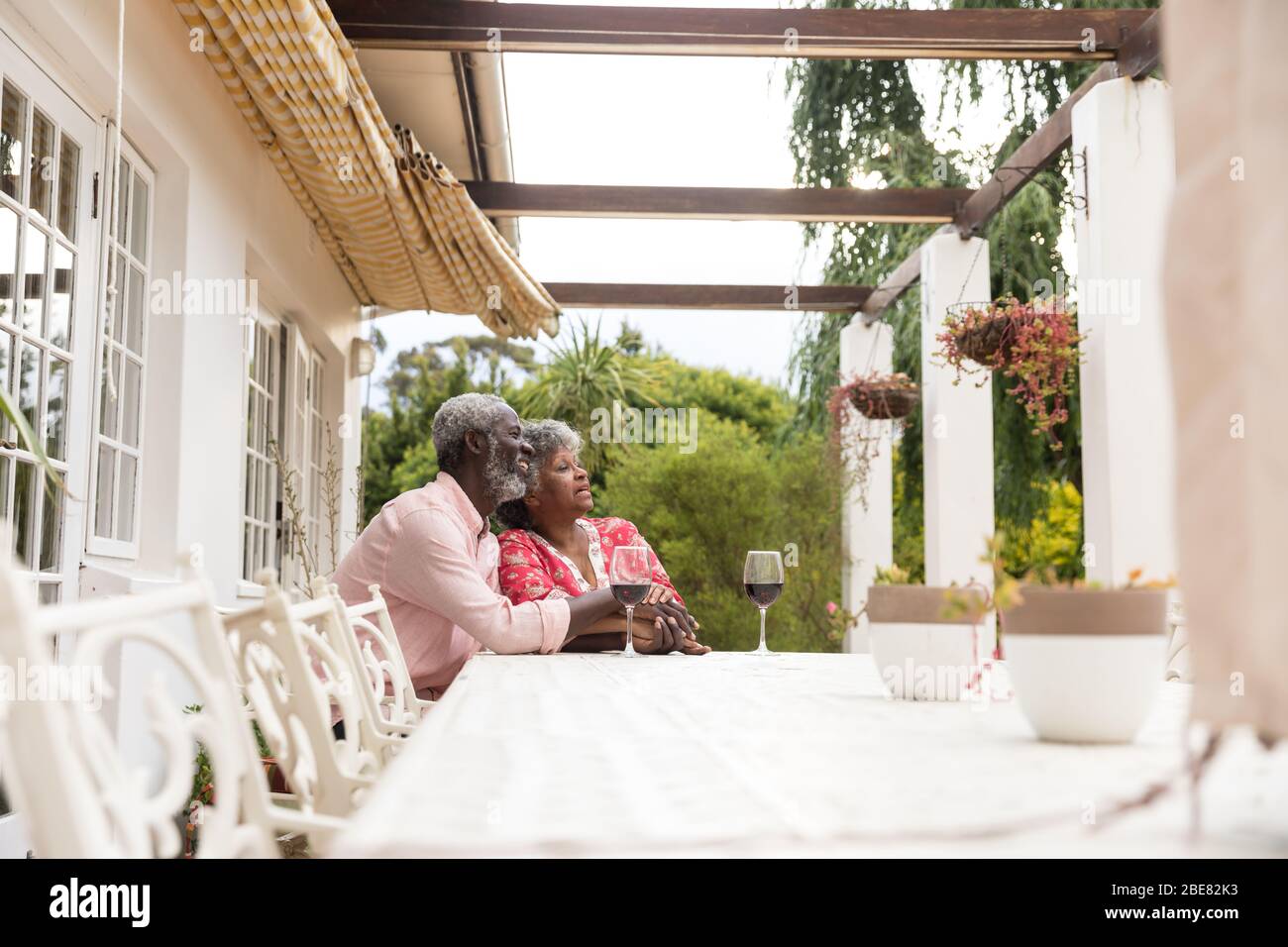 Una coppia afro-americana che trascorre il tempo insieme in giardino e beve vino Foto Stock