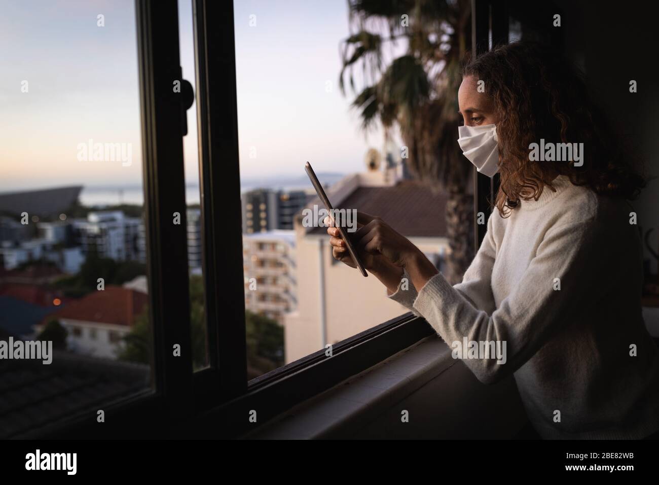 Donna che usa il suo tablet digitale. Distanza sociale in blocco di quarantena durante l'epidemia di coronavirus Foto Stock
