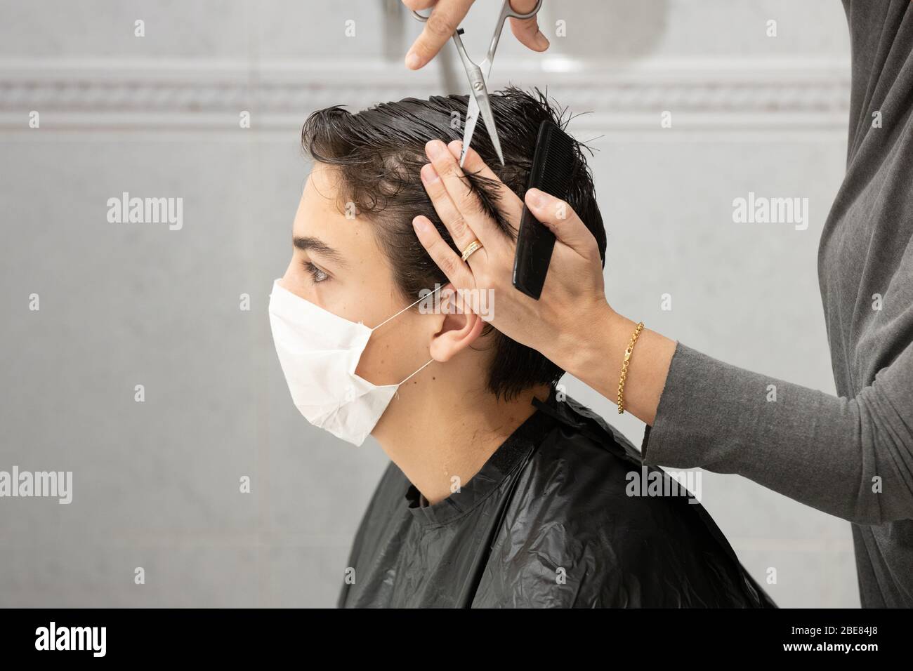 Madre che taglia i capelli del suo figlio a casa approfittando del confinamento dal Covid-19 Foto Stock