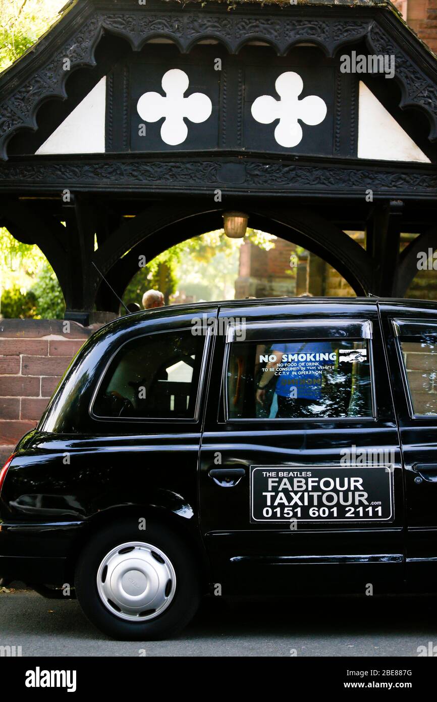 Il Tour in taxi nero parcheggiato di fronte alla chiesa di St Peters a Woolton Village Liverpool, dove John Lennon e Paul McCartney suonarono insieme per la prima volta Foto Stock