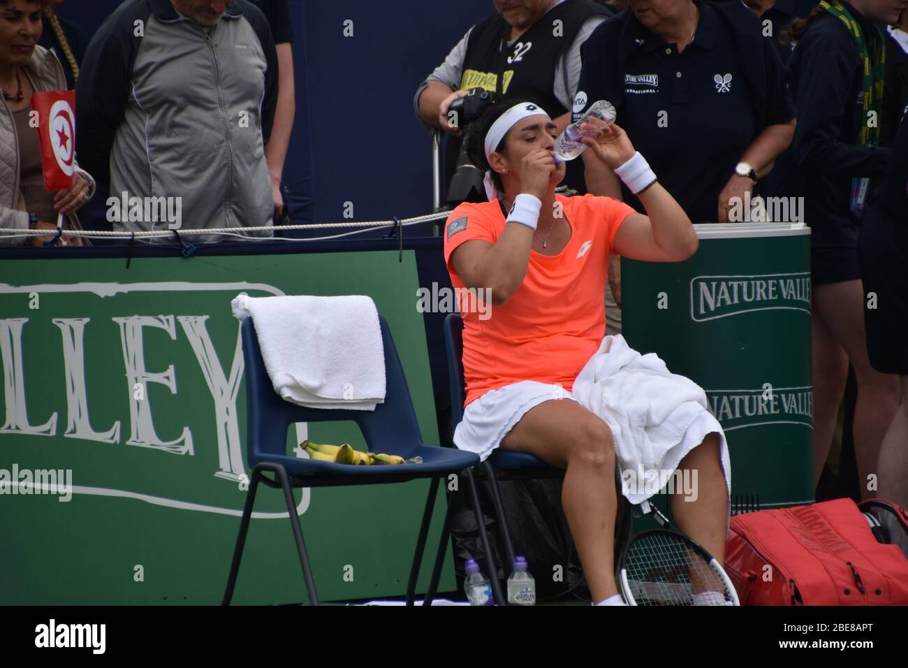 Ons Jabeur la tennista tunisina che beve un drink mentre si sedette tra una partita e l'altra in una partita di tennis femminile, Eastbourne 2019 Foto Stock