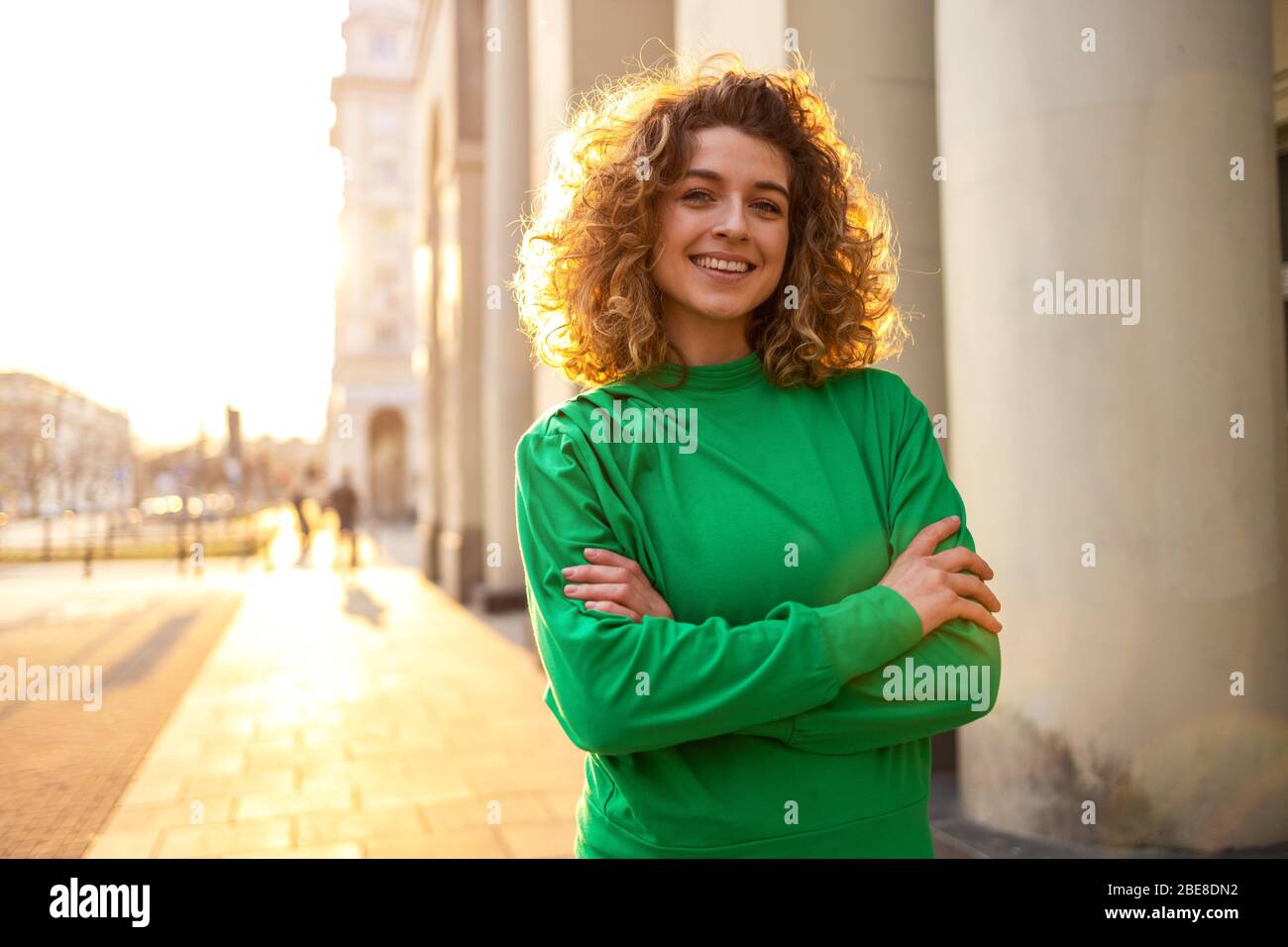 Ritratto di giovane donna con capelli ricci in città Foto Stock