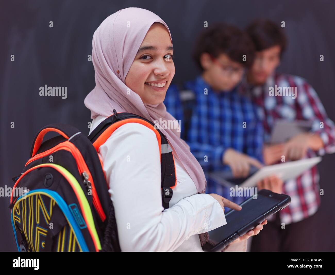 Team di adolescenti arabi, gruppo di studenti che lavorano insieme sul concetto di formazione in aula online di computer portatili e tablet Foto Stock