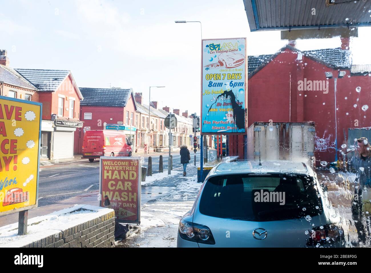 Il piazzale di una stazione di servizio convertita che ora è usata come lavaggio di automobile usando il lavoro immigrato sulla strada alta di Wavertree in Liverpool Urban, Inghilterra Foto Stock