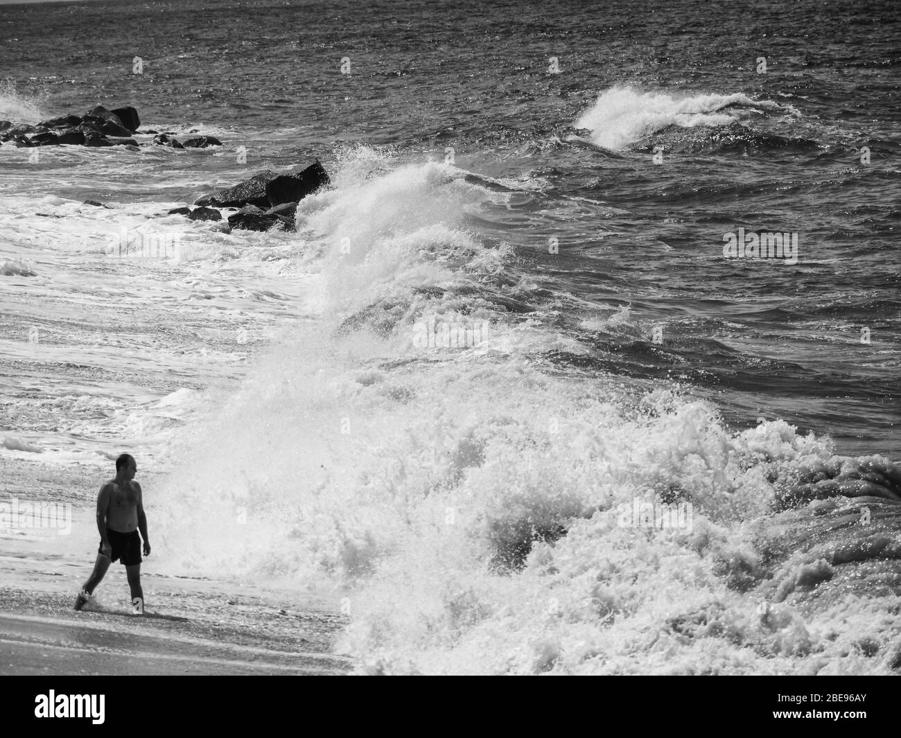 Bagnatevi sulla spiaggia durante una tempesta pesante. Onde che si infrangono potentemente sulla riva. Foto Stock