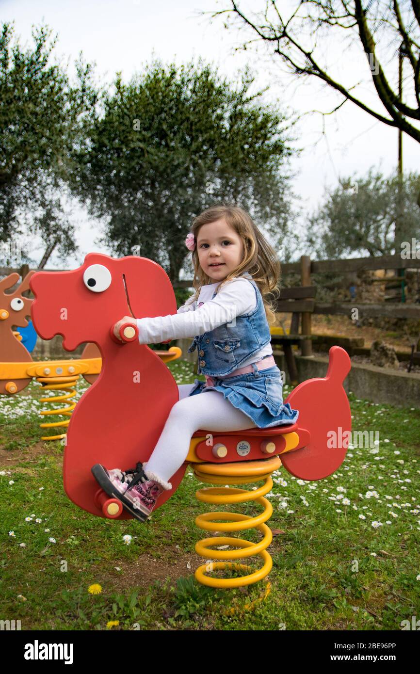 Verona, Italia - 29 marzo 2015: Il bambino gioca su un cane da primavera letto in un parco giochi. Foto Stock