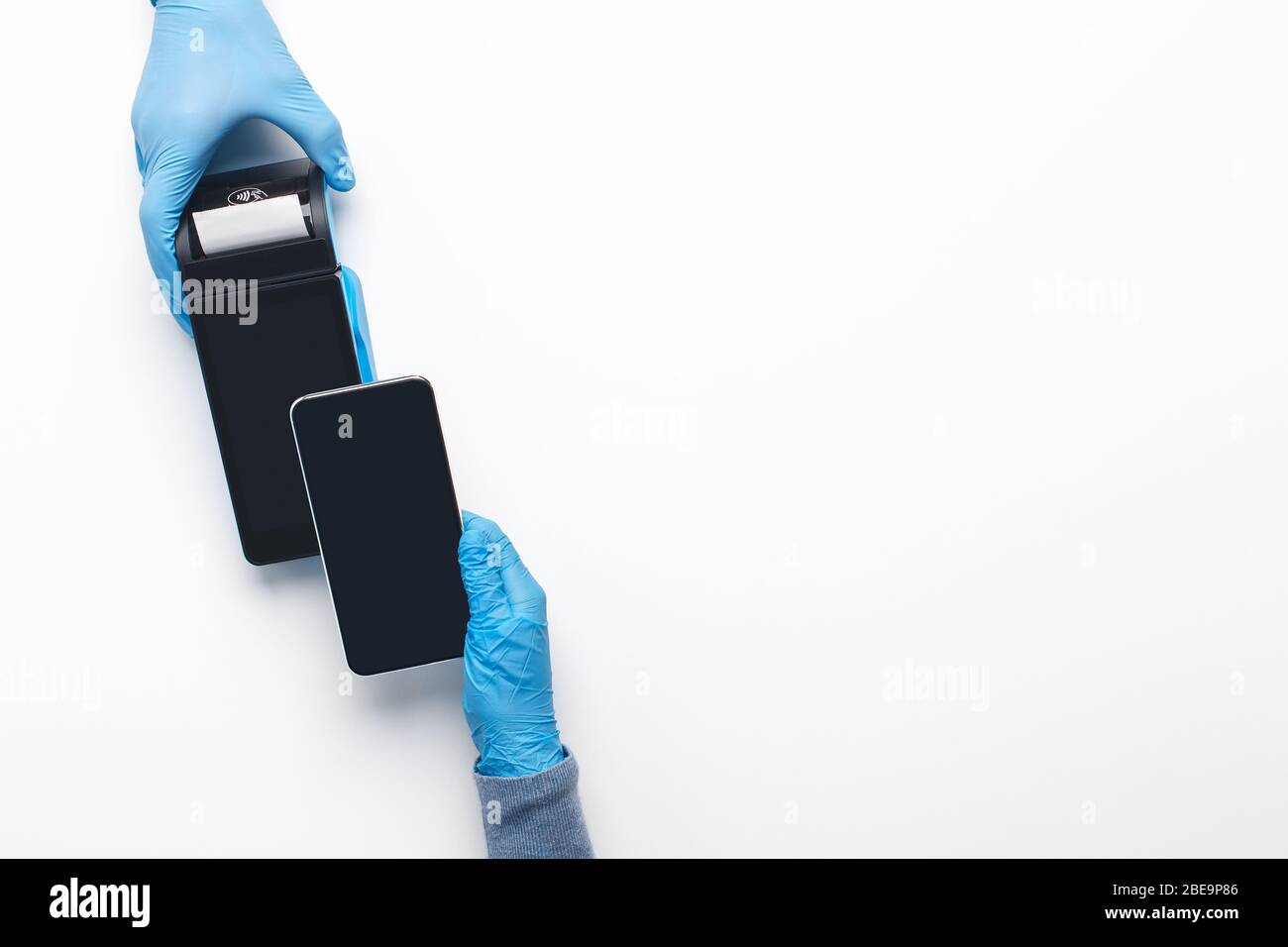 Uomo in guanti di protezione a pagamento con telefono cellulare, pay pass Foto Stock