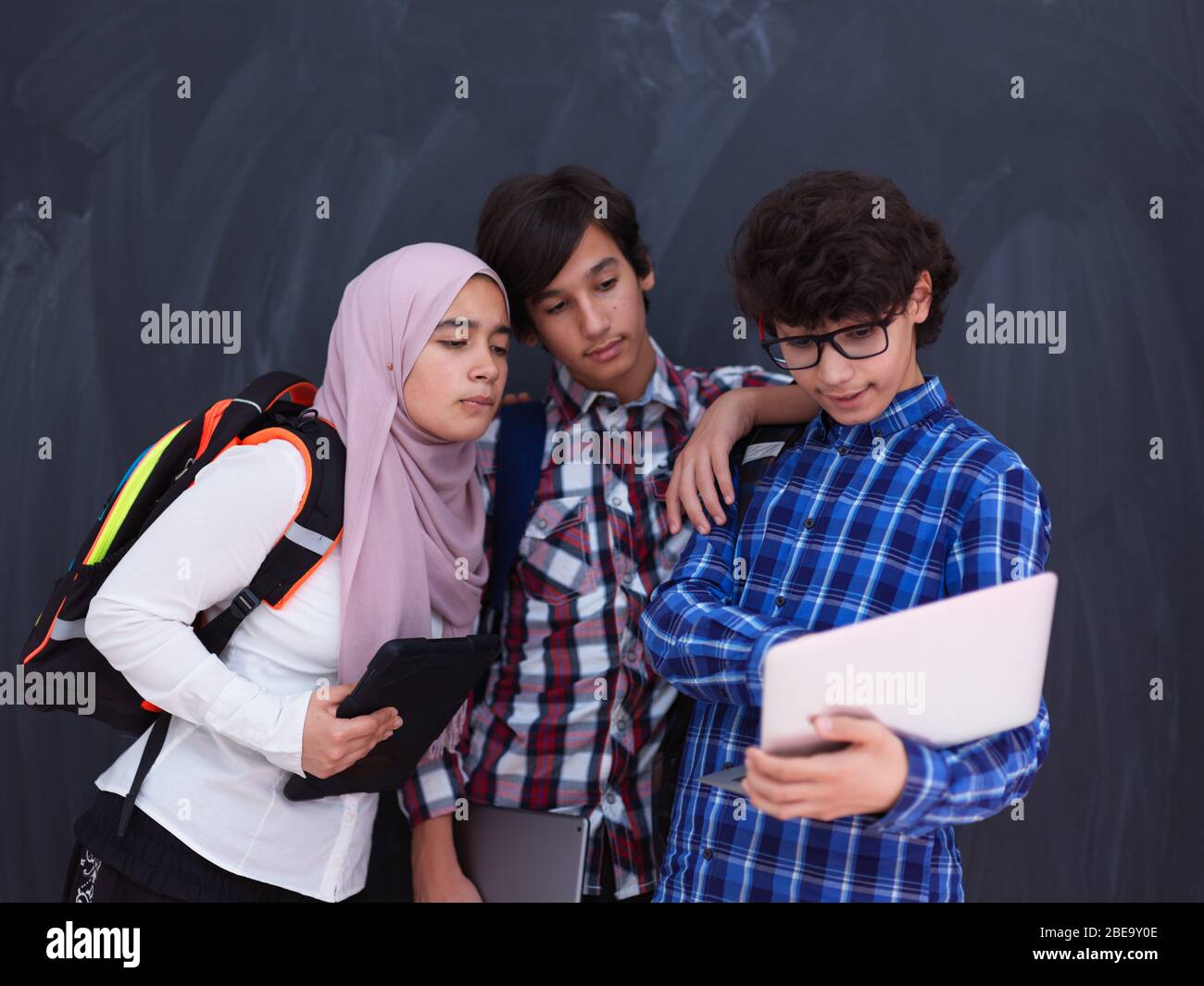 Team di adolescenti arabi, gruppo di studenti che lavorano insieme sul concetto di formazione in aula online di computer portatili e tablet Foto Stock