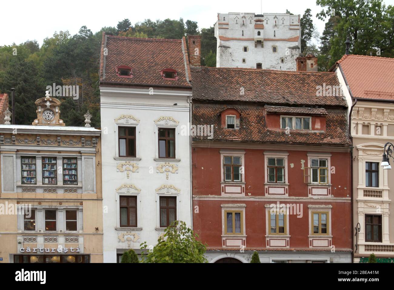 Vecchi edifici adiacenti che circondano la Piazza della Sala di Brasov, Romania, con la Torre di Orologio Bianca vista sul retro Foto Stock