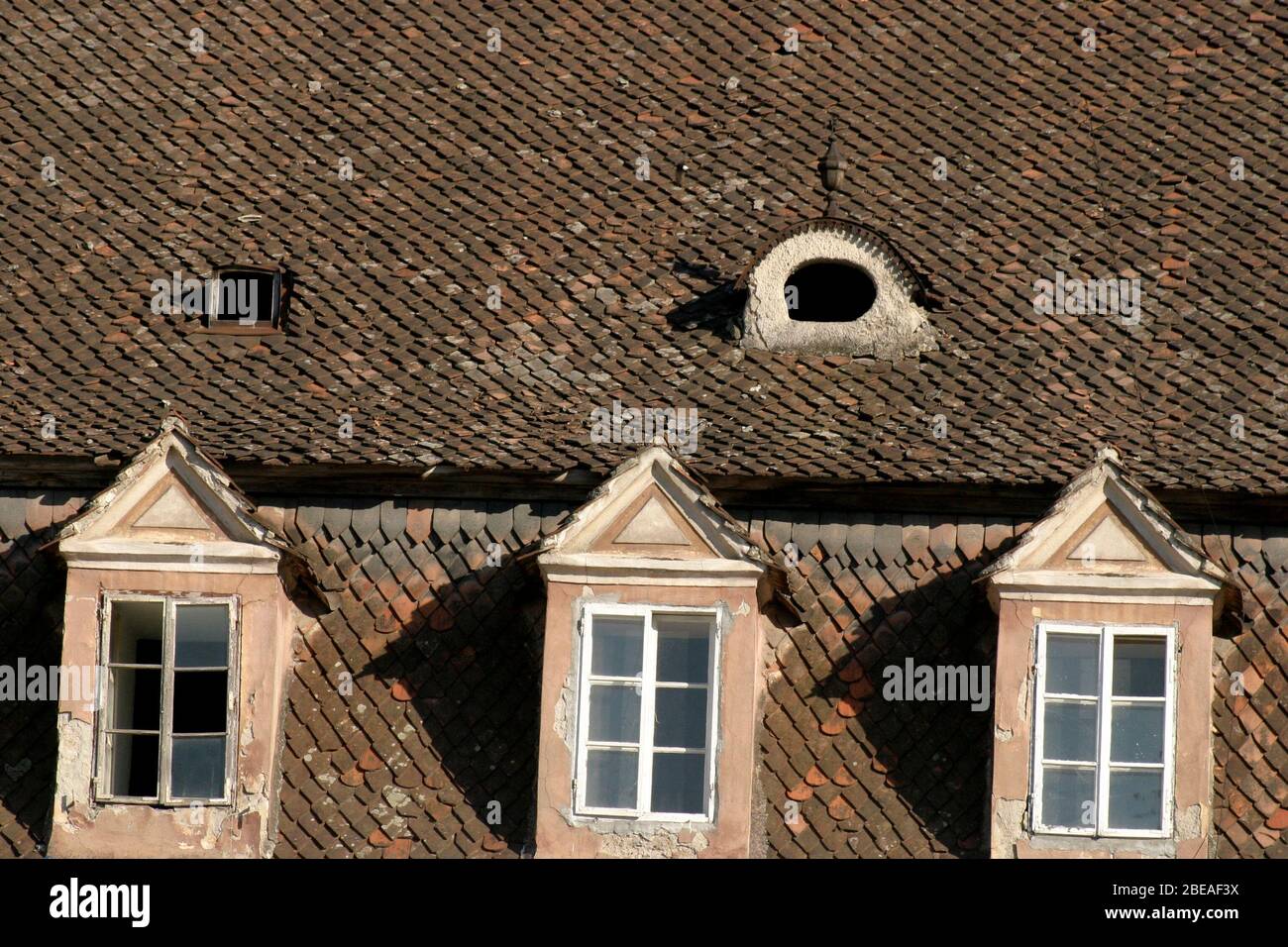 Finestre dormer sulla casa coperta con piastrelle di argilla originale nella città vecchia di Brasov, Romania Foto Stock