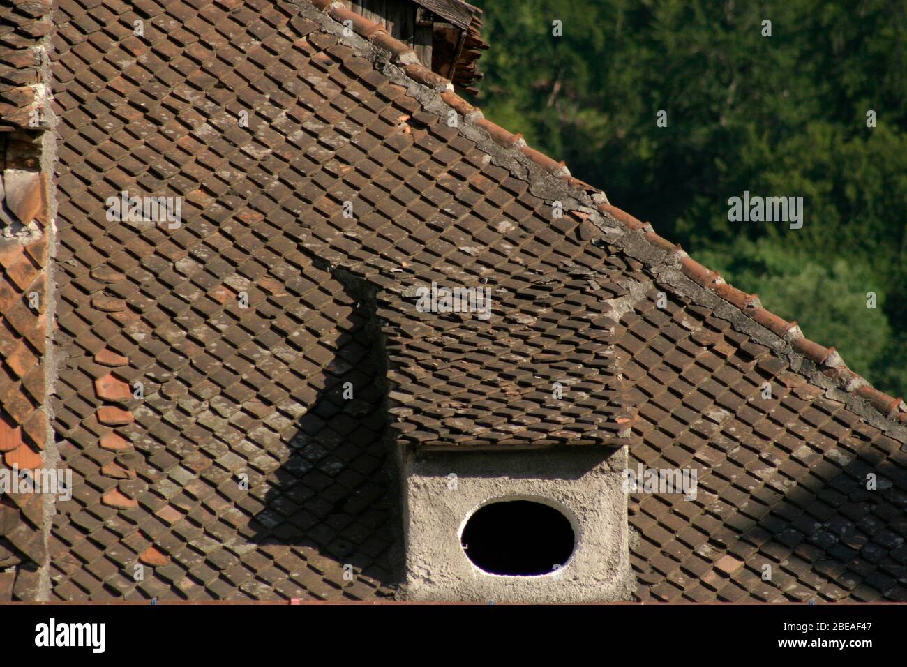 Finestre dormer sulla casa coperta con piastrelle di argilla originale nella città vecchia di Brasov, Romania Foto Stock