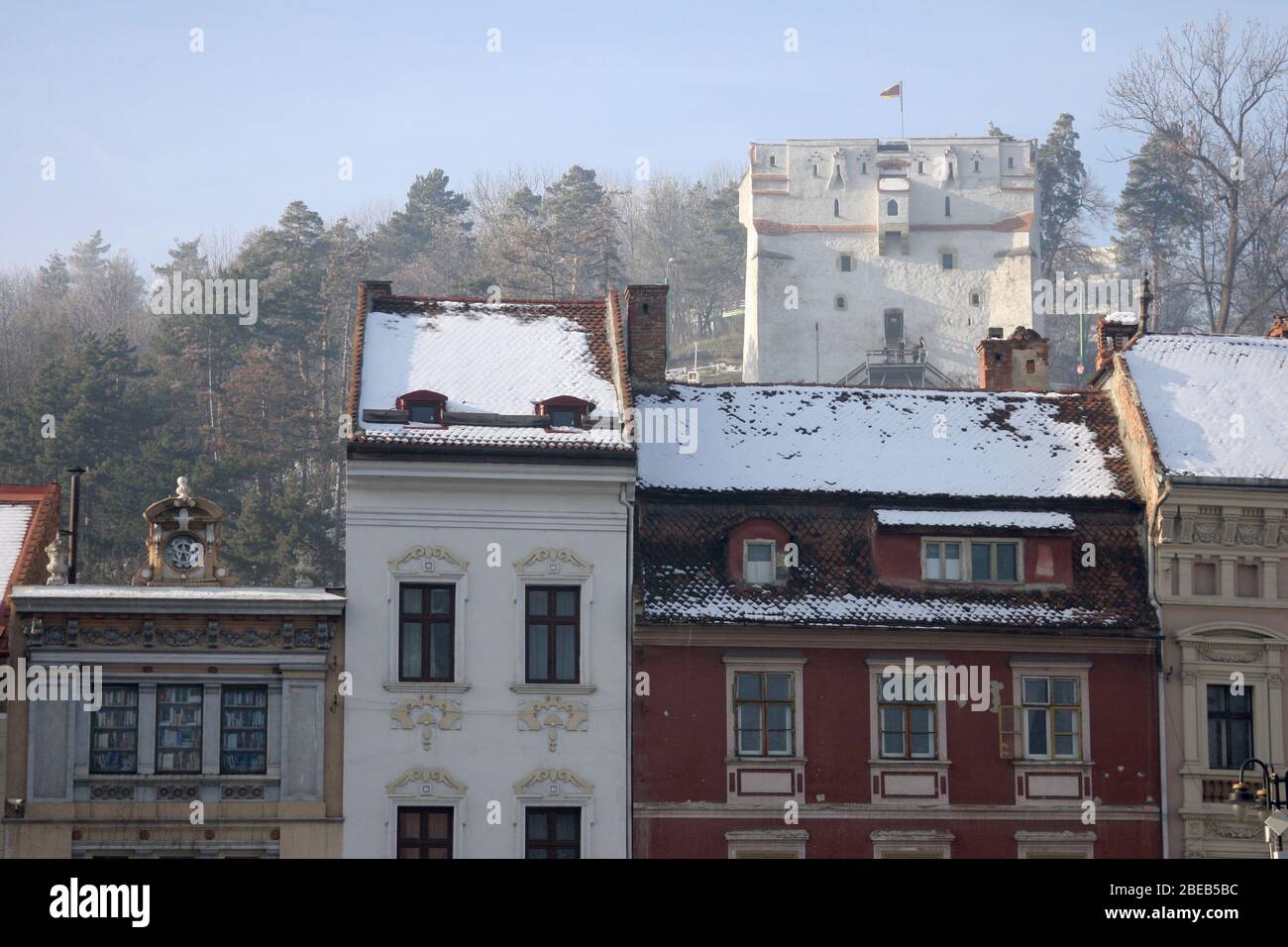 Vecchi edifici adiacenti che circondano la Piazza della Sala di Brasov, Romania, con la Torre di Orologio Bianca vista sul retro Foto Stock