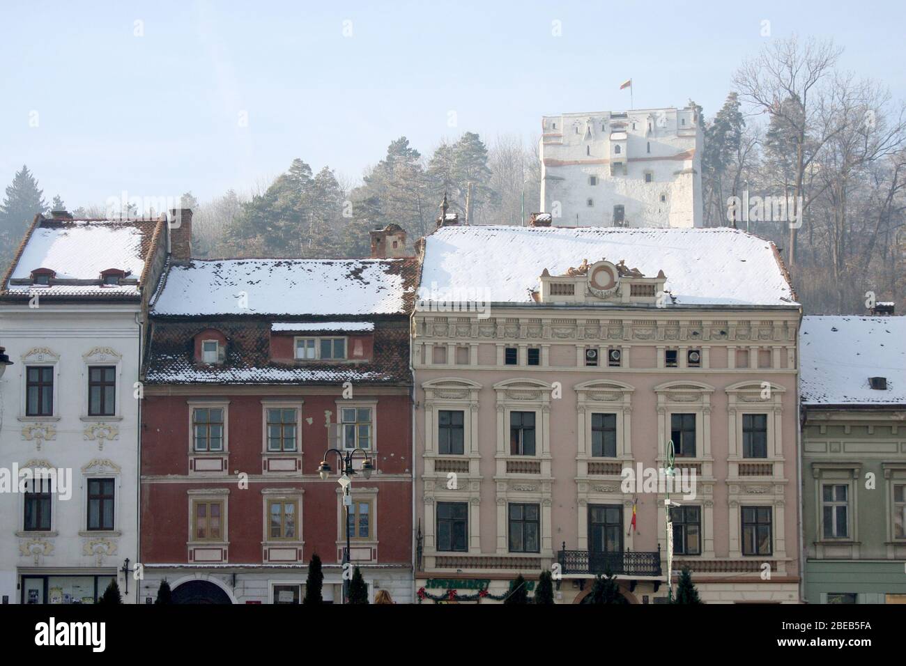 Vecchi edifici adiacenti che circondano la Piazza della Sala di Brasov, Romania, con la Torre di Orologio Bianca vista sul retro. Safrano Palace (il più grande). Foto Stock