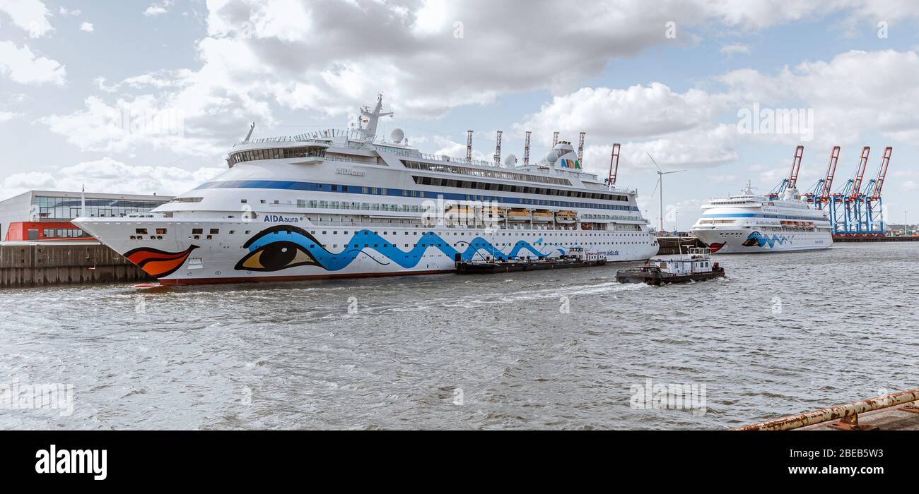 13 aprile 2020, Amburgo: Le navi da crociera AIDAaura (l) e AIDAcara sono ormeggiate al terminal dei traghetti di Steinwerder. Come misura per contenere la pandemia corona, hanno temporaneamente sospeso le loro crociere. Foto: Markus Scholz/dpa Foto Stock