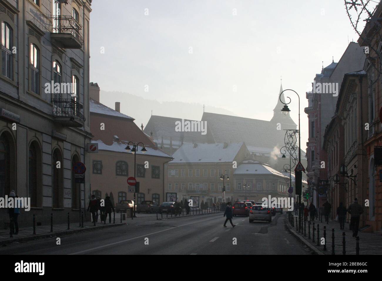 Strada Muresenilor, strada nella città vecchia di Brasov, Romania, in inverno. La silhouette della Chiesa Nera sullo sfondo. Foto Stock
