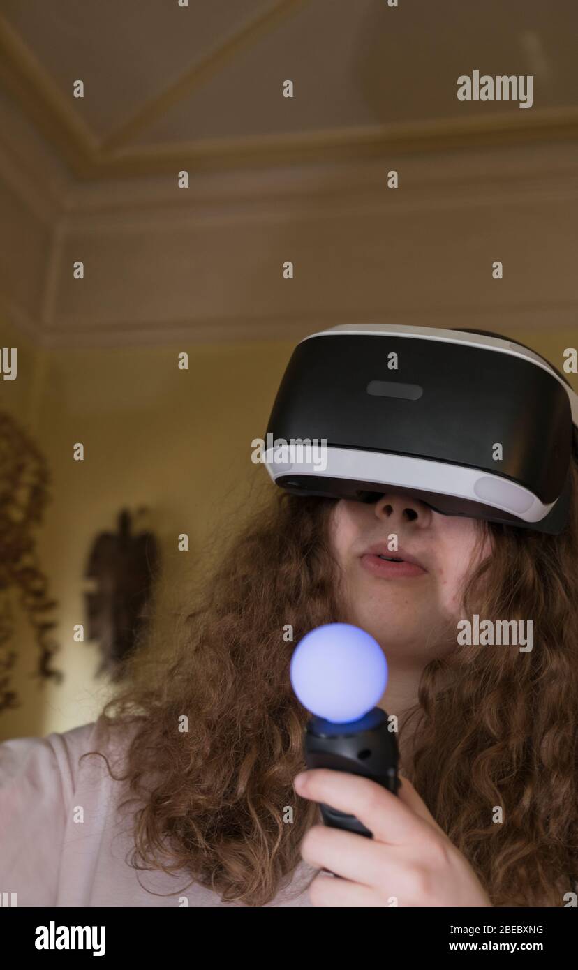 Ragazza che gioca a un gioco virtuale con la cuffia a casa. Londra, Inghilterra Foto Stock