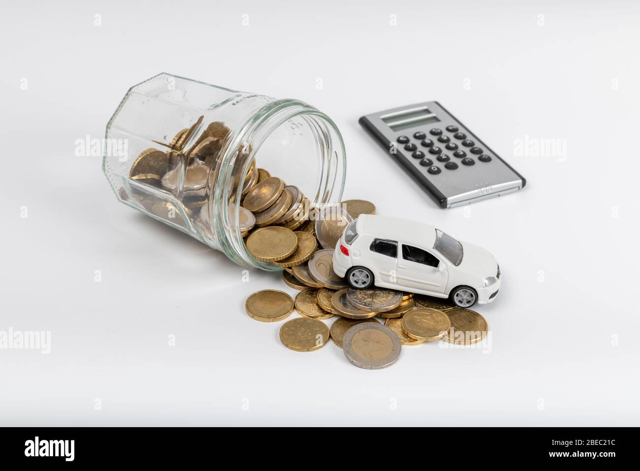 Modello di automobile in miniatura e bilancio con monete. Finanza e prestito auto, risparmio di denaro per un auto o materiali di progettazione concetti. Foto Stock