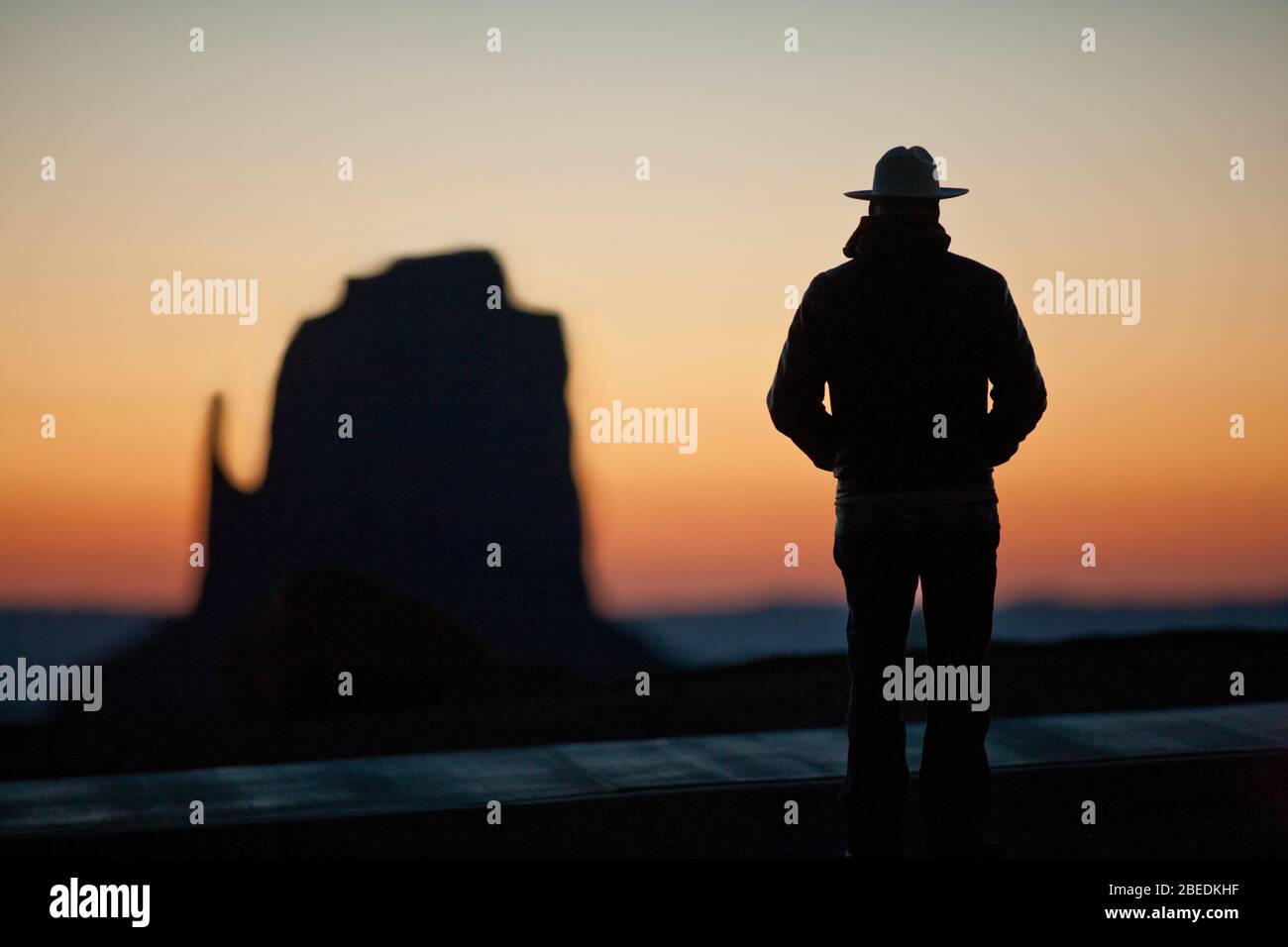 Park ranger guardando un paesaggio desertico al tramonto Foto Stock