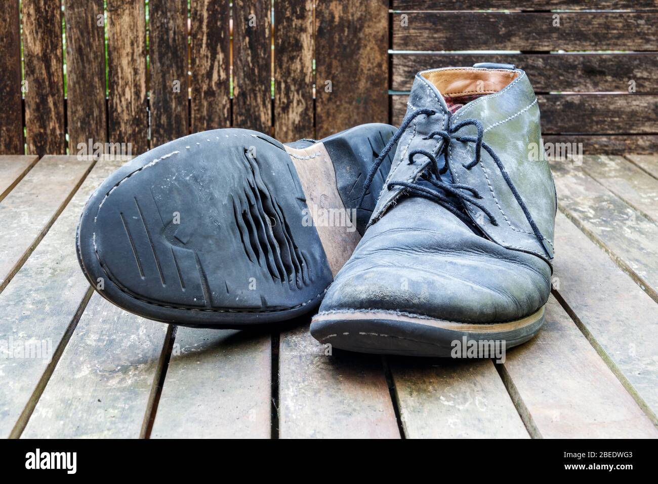 Un paio di scarpe con lacci in pelle nera sporca e logore Foto Stock