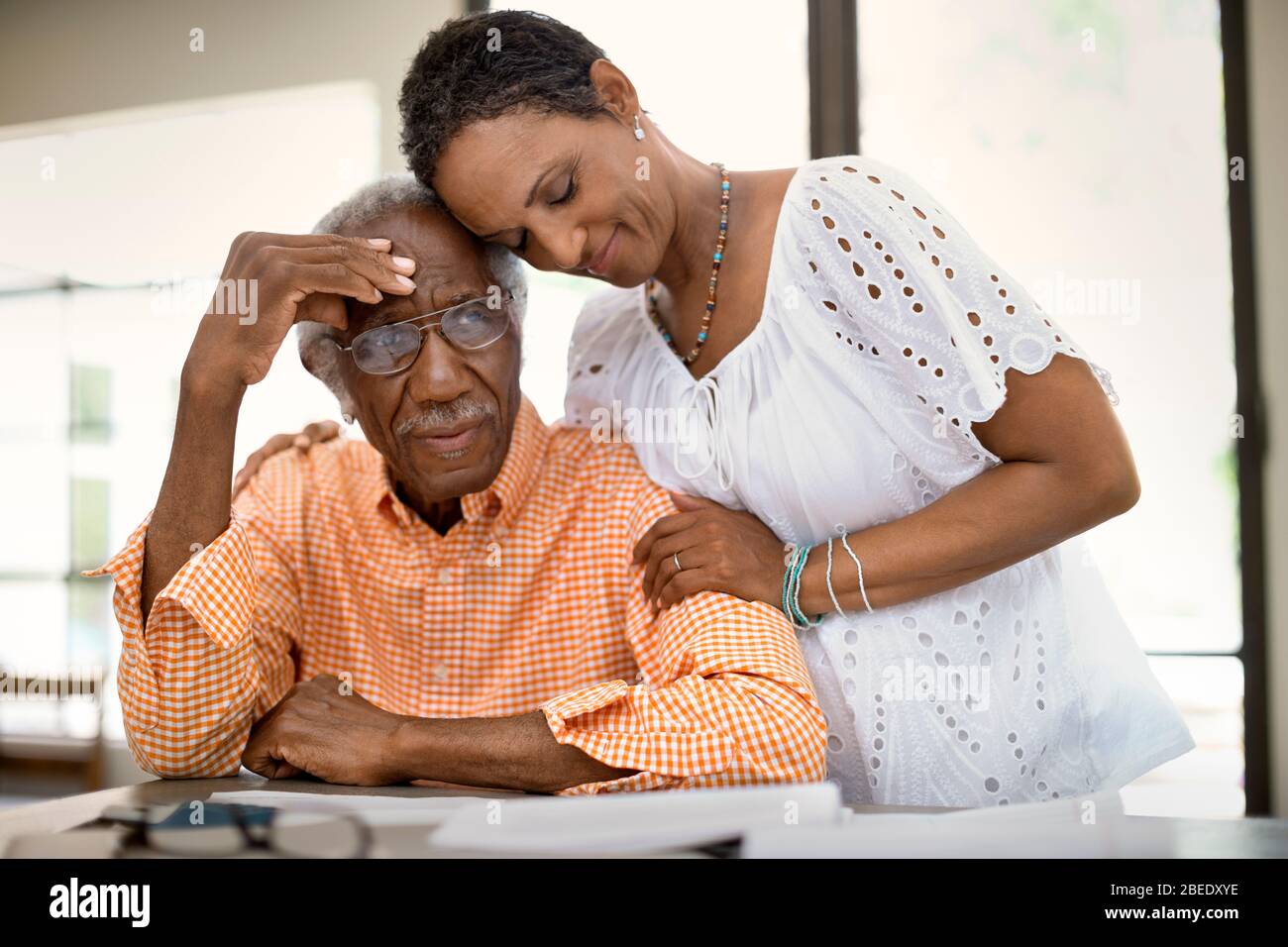 Donna di mezza età adulta confortando il suo padre senior mentre andando oltre le finanze personali Foto Stock