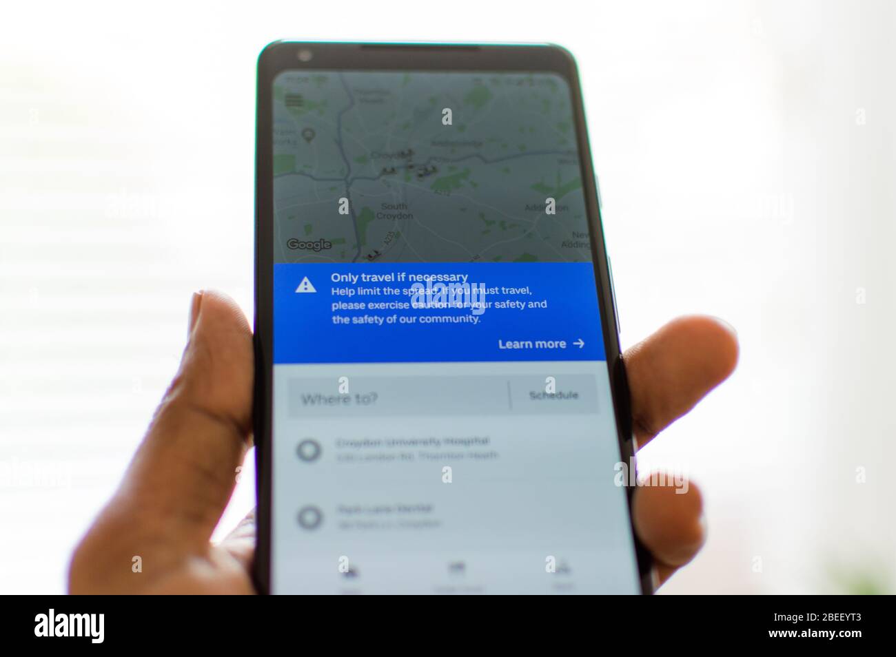 UBER app ride sharing avvisa gli utenti di viaggiare solo se necessario e contribuire a limitare la diffusione di coronavirus pandemico / covid-19 Foto Stock
