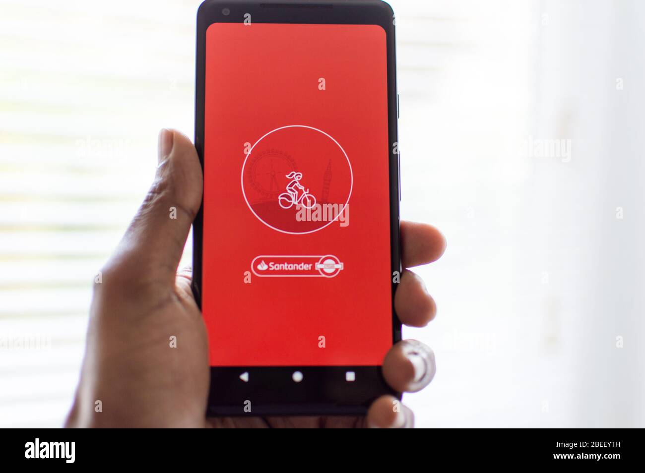 App per la condivisione di biciclette Santander sul telefono cellulare tenuto da MAN Foto Stock