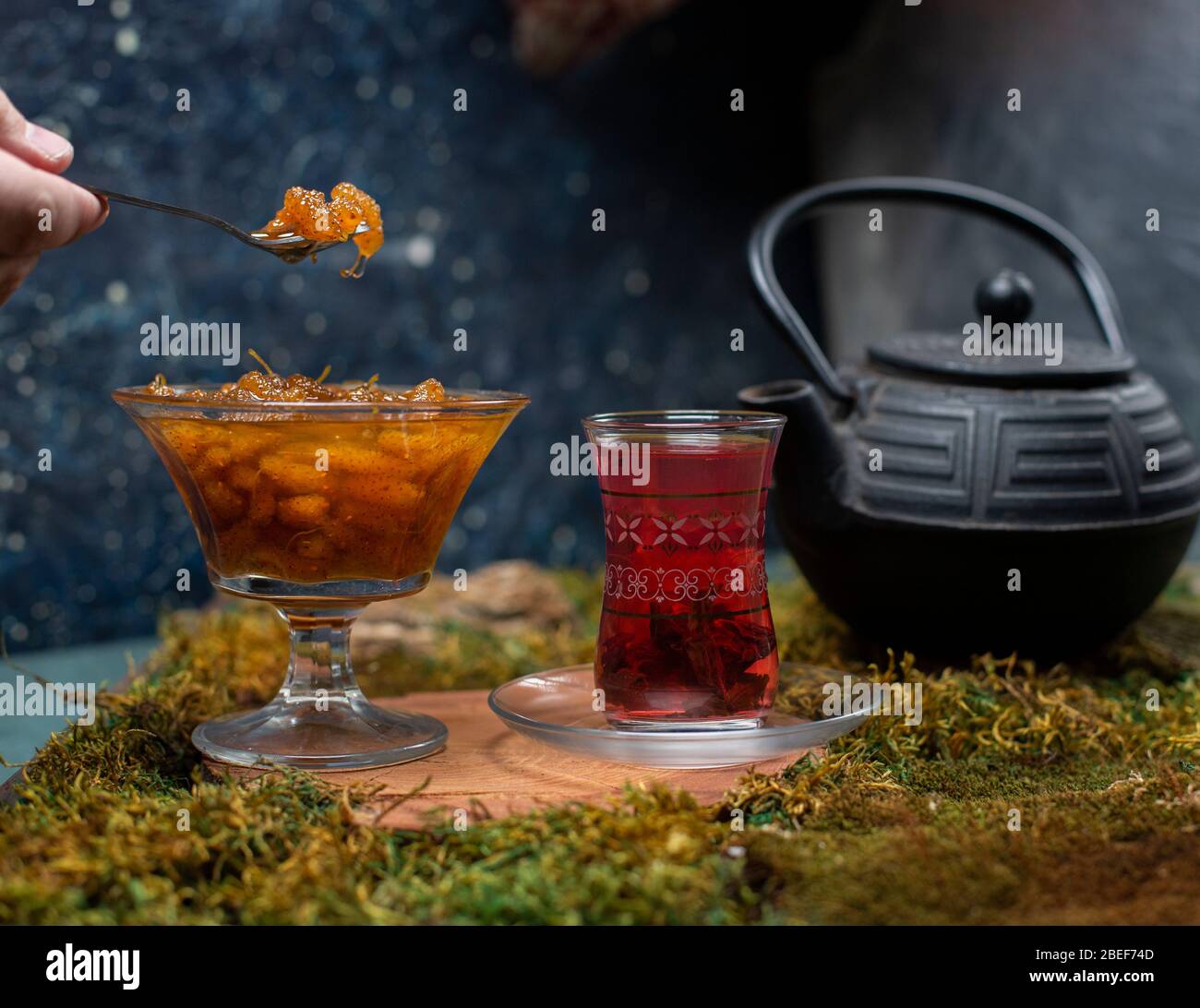 tè, teiera e gustosa marmellata con sfondo scuro Foto Stock