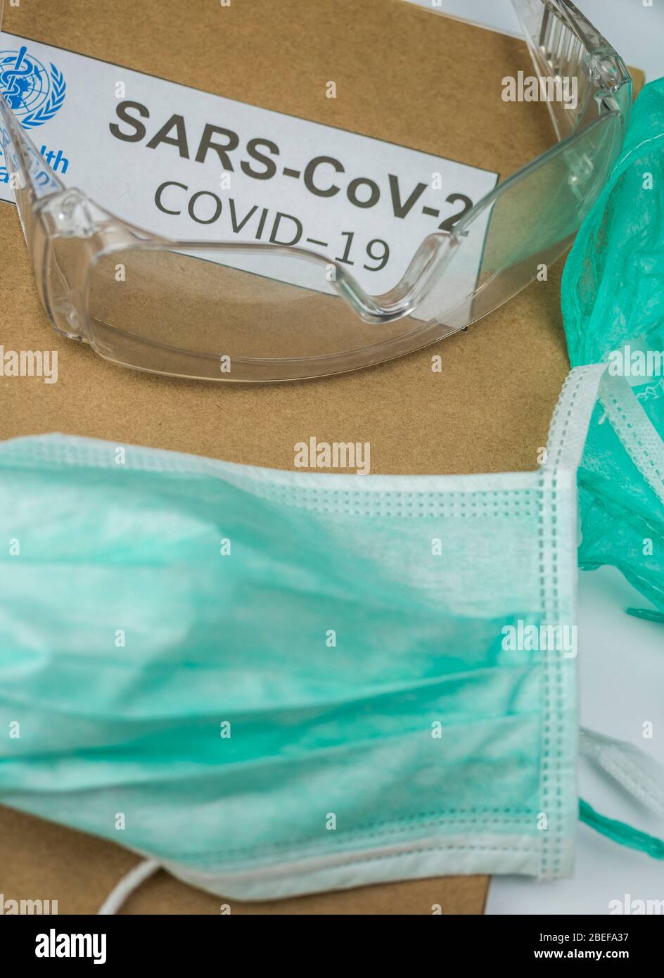 Occhiali protettivi e maschera su un dossier coronavirus, immagine concettuale Foto Stock