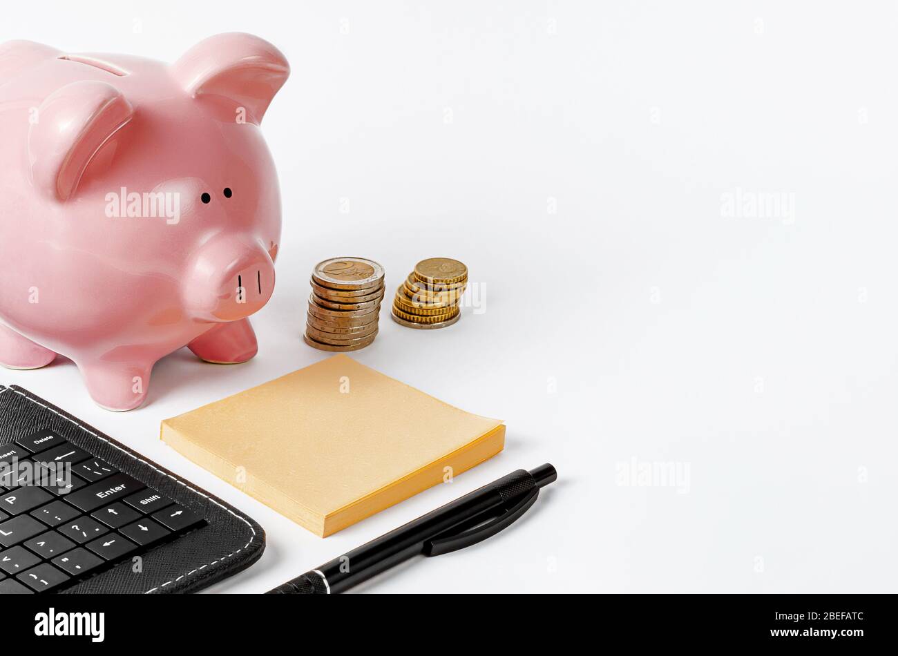 Piggy bank sulla scrivania bianca dell'ufficio. Sviluppo aziendale e concetto di investimento. Spazio di copia Foto Stock
