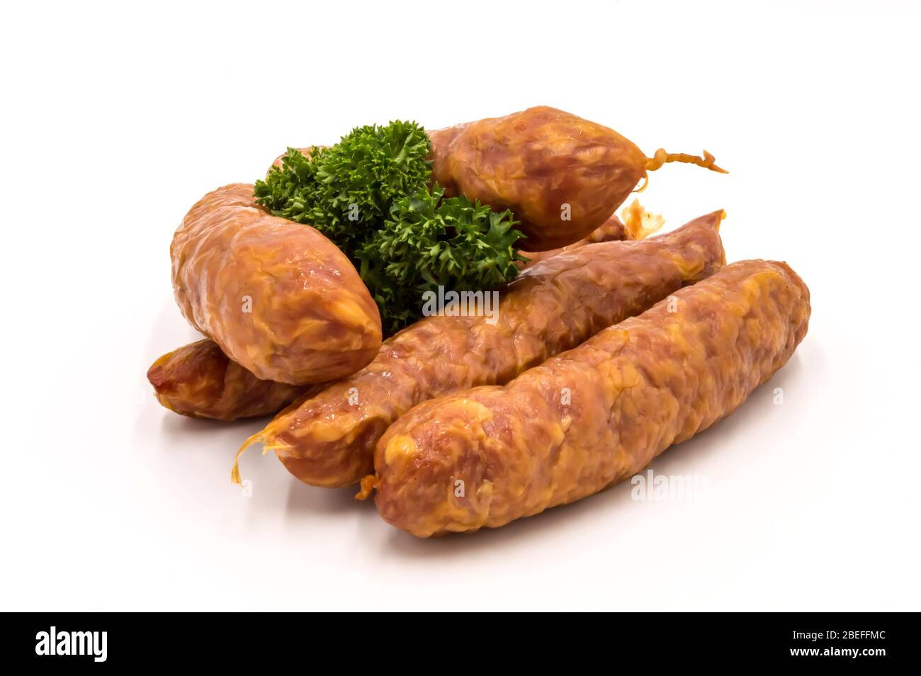 Salsicce affumicate su fondo bianco con un rametto di salsicce alla gaumaise di prezzemolo Foto Stock