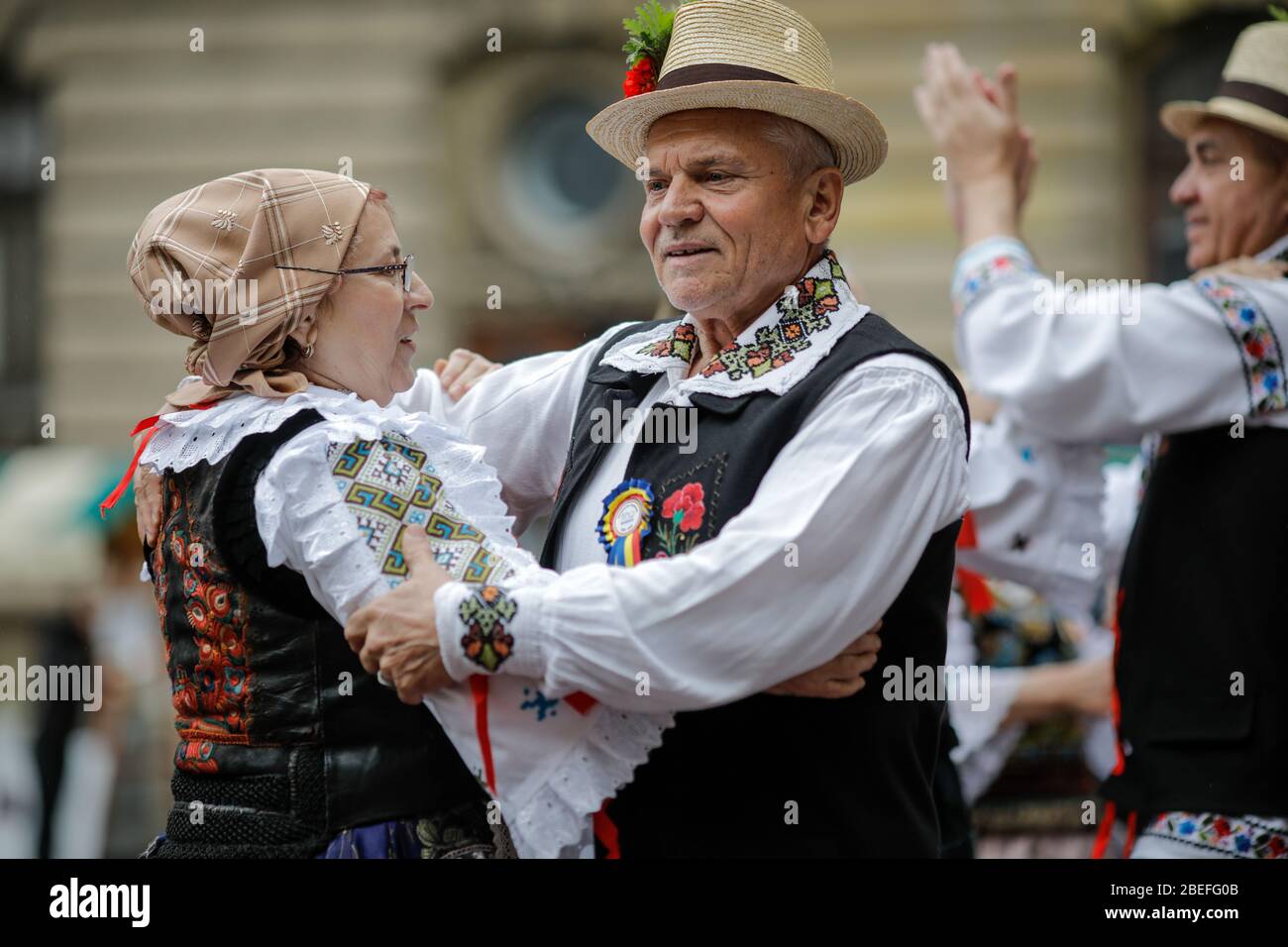 Bucarest, Romania - 5 marzo 2020: Donne e uomini anziani, vestiti con abiti tradizionali rumeni, ballano in un festival. Foto Stock